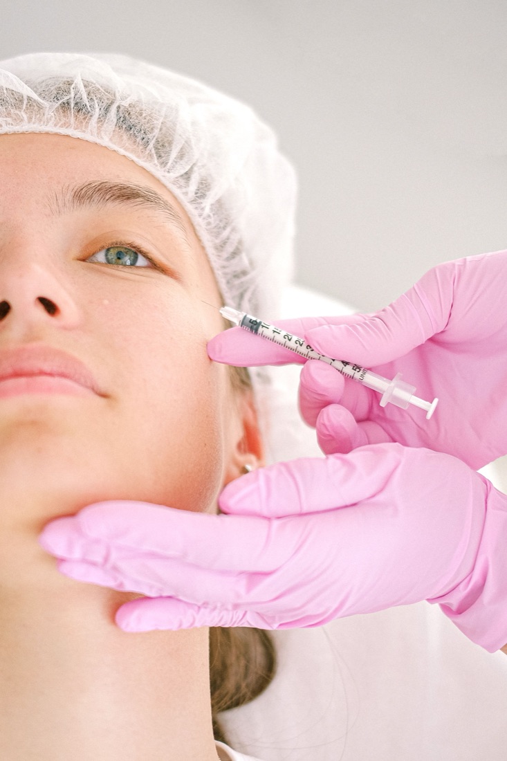 Licensed injector performing a Botox treatment with pink gloves during an in-home concierge visit